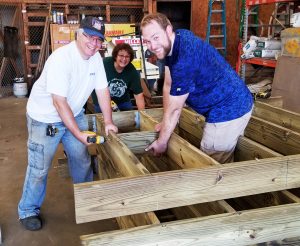 Three people working in DPW garage (left to right) Jerry Comella, Susan Torpy, and Joe Leatham are part of a team of volunteers from the Church of Jesus Christ of Latter-Day Saints in Brockport. At the DPW garage, they are completing the 44-foot wooden ramp which leads to the floating dock. All the volunteers had lunch that Saturday contributed by Wegman’s in Brockport. Photo by Dianne Hickerson